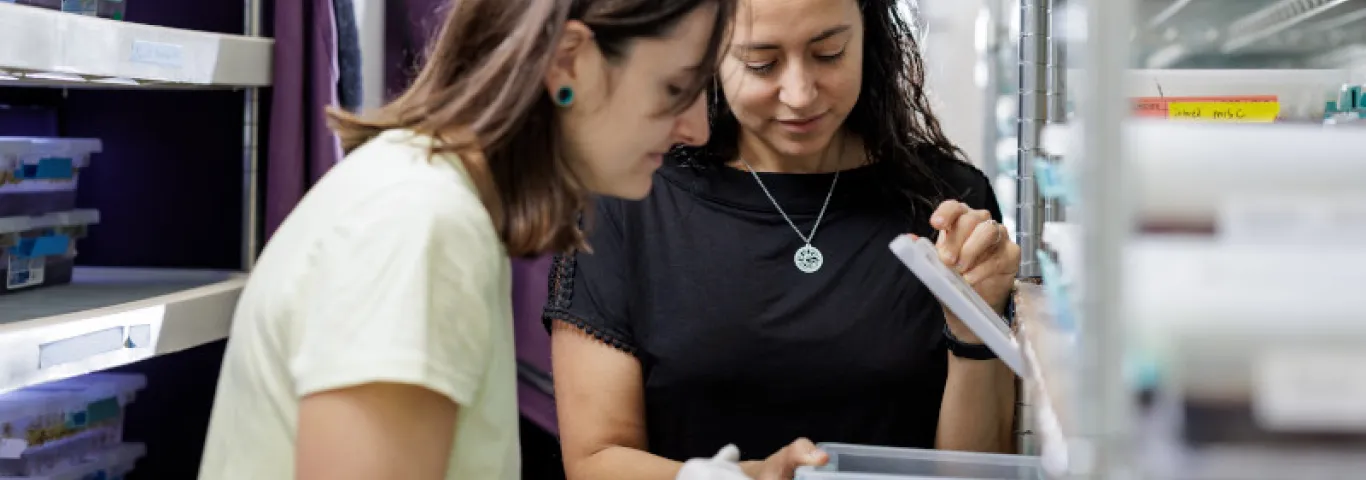two women examine a box of lab materials